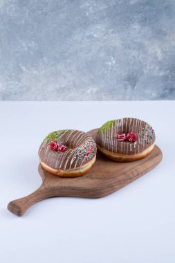 Çikolata kaplamalı çikolatalı donutlardan oluşan tahta bir tahta. Yüksek kalite fotoğraf