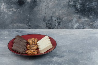 Üzerinde yulaflı kurabiye ve çikolata olan kırmızı bir tabak. Yüksek kalite fotoğraf