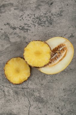 Yarım dilimlenmiş kavun dilimlenmiş, arka planda doğranmış ananas. Yüksek kalite fotoğraf