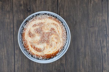 Tahta masaya konmuş şekerli bir tabak lezzetli turta. Yüksek kalite fotoğraf