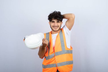 Beyaz duvarın üzerinde duran yakışıklı üniformalı genç adam. Yüksek kalite fotoğraf