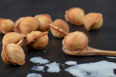 Tahta kaşık cevizli kurabiye ve üzerine siyah süt dökülmüş. Yüksek kalite fotoğraf