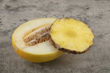 Yarım dilimlenmiş kavun ve arka planda ananas dilimi. Yüksek kalite fotoğraf