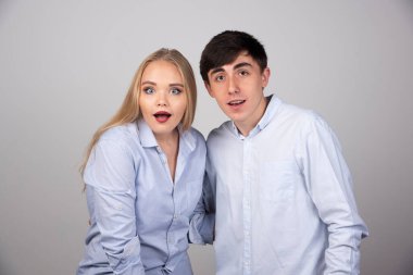 Genç bir çift ayakta durup hayret verici bir şekilde kameraya bakıyor. Yüksek kalite fotoğraf