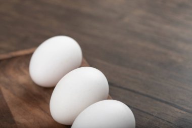 Ahşap arka planda ahşap tepside üç taze yumurta. Yüksek kalite fotoğraf