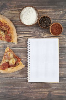 Tahta bir masada dizüstü bilgisayarı olan lezzetli pizza dilimleri. Yüksek kalite fotoğraf