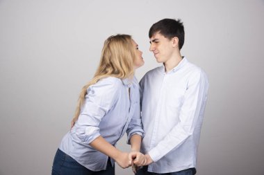 Gri arka planda birbirine bakan genç bir çiftin portresi. Yüksek kalite fotoğraf