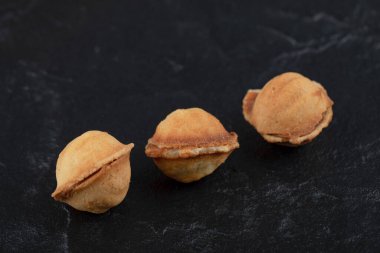 Siyah arka planda ceviz şeklinde ev yapımı lezzetli kurabiyeler. Yüksek kalite fotoğraf