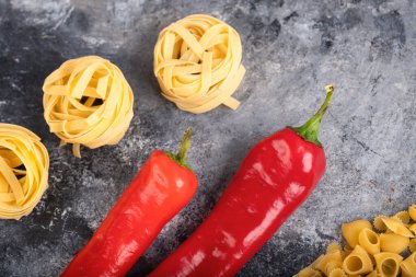 Kuru makarnayla kırmızı biberi mermer yüzeyde karıştırdım. Yüksek kalite fotoğraf