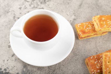 Cup of hot tea with crispy biscuits with sesame seeds. High quality photo