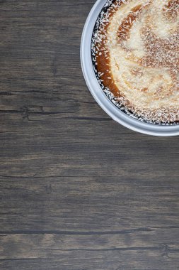 Tahta masaya konmuş şekerli bir tabak lezzetli turta. Yüksek kalite fotoğraf