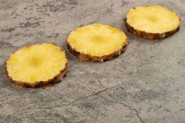 Taş zemine yerleştirilmiş lezzetli ananaslı dilimler. Yüksek kalite fotoğraf