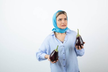 Mendilli, patlıcan tutan sarışın güzel bir kadın resmi. Yüksek kalite fotoğraf