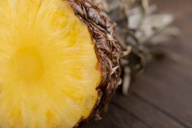 Dilimlenmiş ananas ve yapraklardan yapılmış tacı ahşap arka planda tek parça halinde kesilmiş. Yüksek kalite fotoğraf