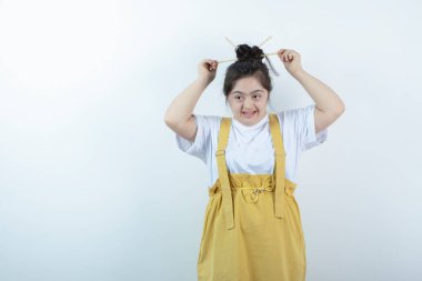 Beyaz duvara karşı duran ve poz veren genç, güzel bir kız. Yüksek kalite fotoğraf