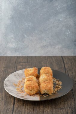 Ahşap masaya yerleştirilmiş lezzetli yuva pastaları tabağı. Yüksek kalite fotoğraf