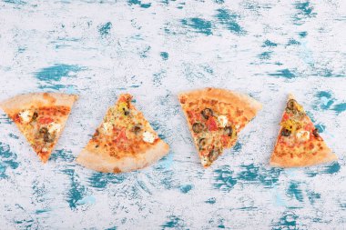 Mermer bir arka planda dilimlenmiş sıcak pizzanın üst görüntüsü. Yüksek kalite fotoğraf