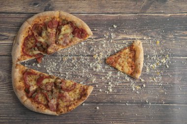 Lezzetli pepperoni ve ahşap masada ekmek kırıntıları olan peynirli pizza. Yüksek kalite fotoğraf