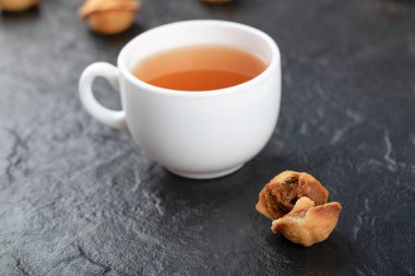 Ceviz şeklinde kurabiyeler ve siyah arka planda bir fincan sıcak çay. Yüksek kalite fotoğraf