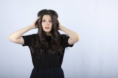 Beyaz arka plandaki bir şeye şaşıran uzun saçlı bir kızın görüntüsü. Yüksek kalite fotoğraf