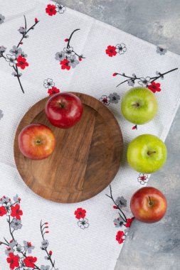 Mermer yüzeyde taze kırmızı ve yeşil elmalardan oluşan ahşap bir tabak. Yüksek kalite fotoğraf