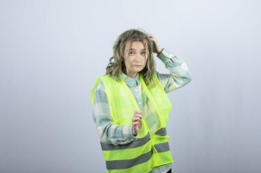 Beyaz duvarın üzerinde duran ve poz veren üniformalı kadın mimarın portresi. Yüksek kalite fotoğraf