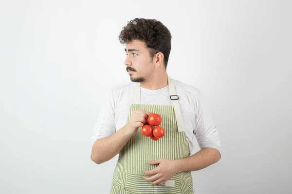 Ung Stilig Kille Som Håller Färska Tomater Och Tittar Bort — Stockfoto