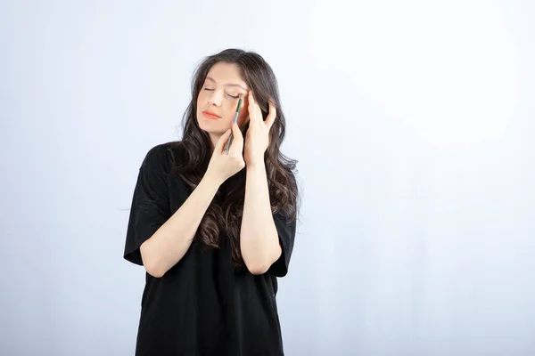 Mulher Bonita Colocando Sombra Com Escova Cosmética Sobre Parede Branca — Fotografia de Stock