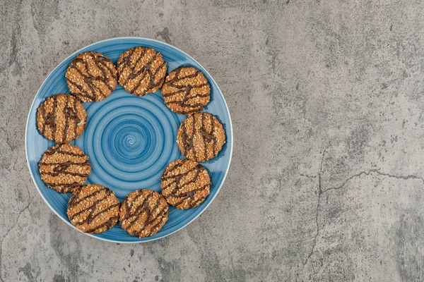 蓝色的饼干盘 上面有种子和巧克力 背景是大理石的 高质量的照片 — 图库照片