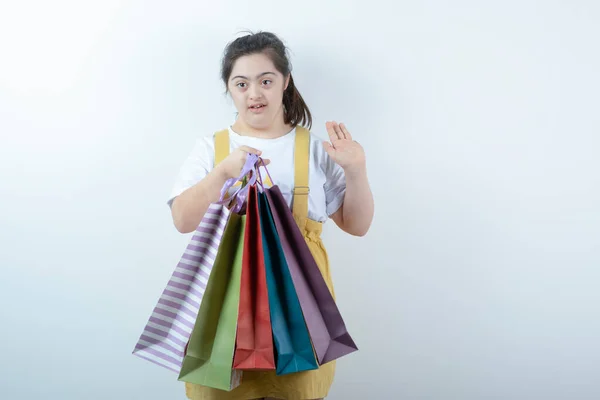 Αξιολάτρευτο Κορίτσι Σύνδρομο Που Κρατάει Τσάντες Για Ψώνια Λευκό Φόντο — Φωτογραφία Αρχείου