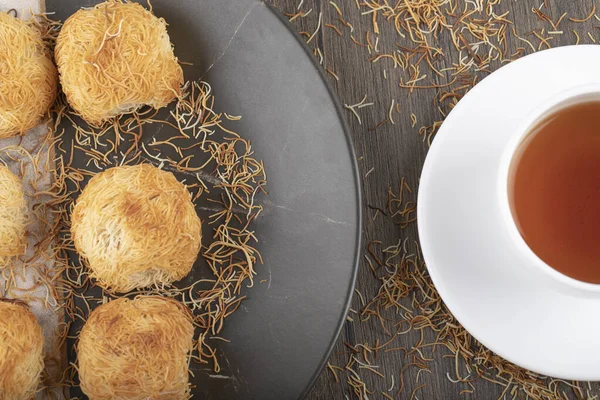 Tahta masaya beyaz bir fincan sıcak çay konmuş Türk tatlıları. Yüksek kalite fotoğraf