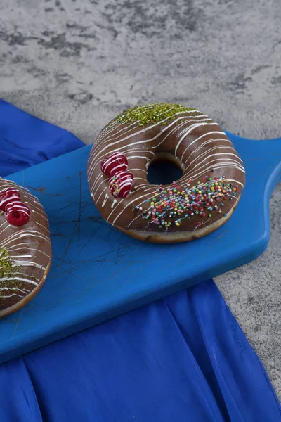 Два Восхитительных Шоколадных Пончика Голубой Разделочной Доске Высокое Качество Фото — стоковое фото