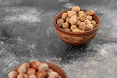 Tabaklar dolusu sağlıklı fıstık ve kabuklu fındıklar bir taş masaya konmuş. Yüksek kalite fotoğraf