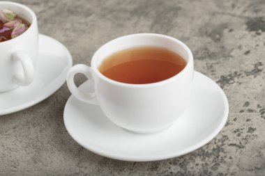 Taş yüzeyinde kurumuş güllerle iki fincan siyah çay. Yüksek kalite fotoğraf