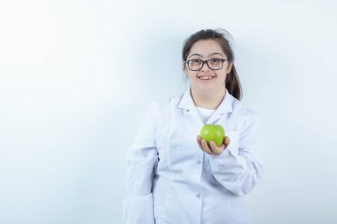 Elinde yeşil elma tutan doktor üniformalı genç bir kız. Yüksek kalite fotoğraf
