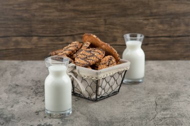 Sepetinde çikolata jöleli leziz çoklu tahıllı kurabiyeler ve iki bardak süt kavanozu. Yüksek kalite fotoğraf