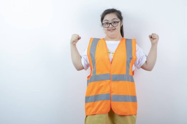 Gözlüklü genç bayan mühendis beyaz arka planda yumruklarını gösteriyor. Yüksek kalite fotoğraf
