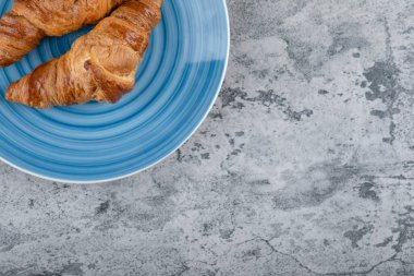 Taştan bir arka planda iki sade kruvasan tabağı. Yüksek kalite fotoğraf