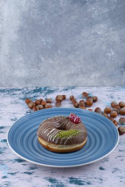 Çikolatalı çörek ve beyaz yüzeyde kabuklu fındık. Yüksek kalite fotoğraf