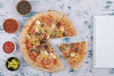 Acı pizza dilimleri, biberli ve biber tozlu mermer arka planda. Yüksek kalite fotoğraf