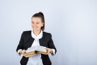 Beyaz duvarda kitap okuyan genç bir kız öğrencinin portresi. Yüksek kalite fotoğraf