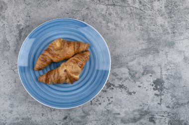 Taştan bir arka planda iki sade kruvasan tabağı. Yüksek kalite fotoğraf