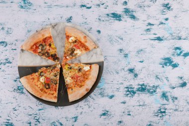 Mermer arka planda bir tabakta sıcak pizza dilimleri. Yüksek kalite fotoğraf