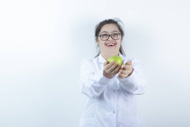 Elinde yeşil elma tutan doktor üniformalı genç bir kız. Yüksek kalite fotoğraf