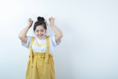 Beyaz duvara karşı duran ve poz veren genç, güzel bir kız. Yüksek kalite fotoğraf