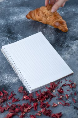 Mermer bir masaya taze, sade kruvasan koyan bir kadın. Yüksek kalite fotoğraf