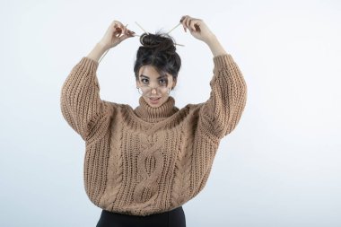 Gözlüklü güzel bir kadının portresi. Kalemle saçını yapıyor. Yüksek kalite fotoğraf