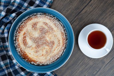 Tahta masaya bir fincan siyah çay ile bir tabak lezzetli turta. Yüksek kalite fotoğraf