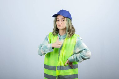 Beyaz duvarın üzerinde duran üniformalı kadın mimarın portresi. Yüksek kalite fotoğraf