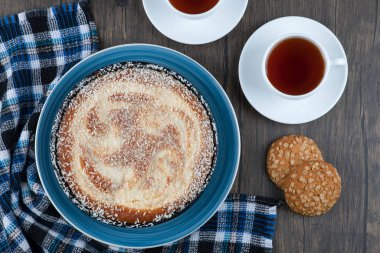 Tahta masaya konmuş turta ve çayla yerleştirilmiş tahıllı yulaf ezmeli kurabiyeler. Yüksek kalite fotoğraf